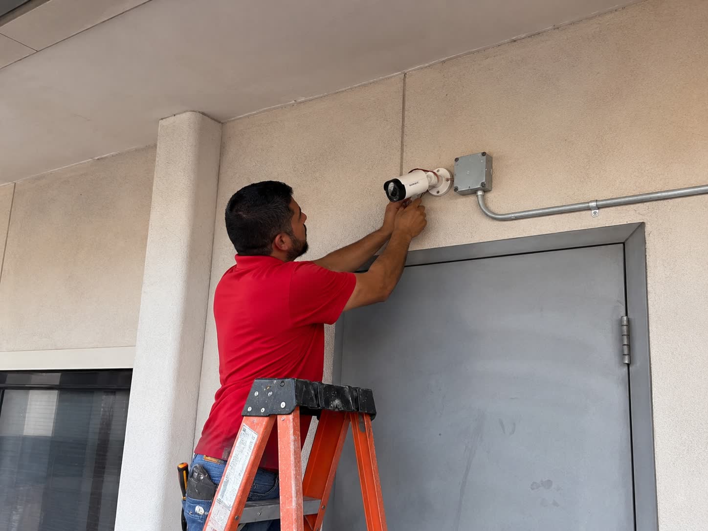 Technician mounting a security camera above a door