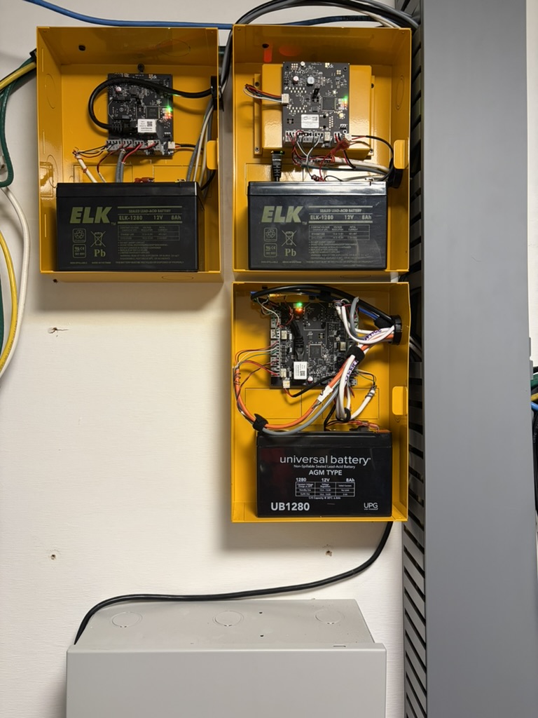 Bank of access-control controllers with battery backups mounted in a wiring cabinet
